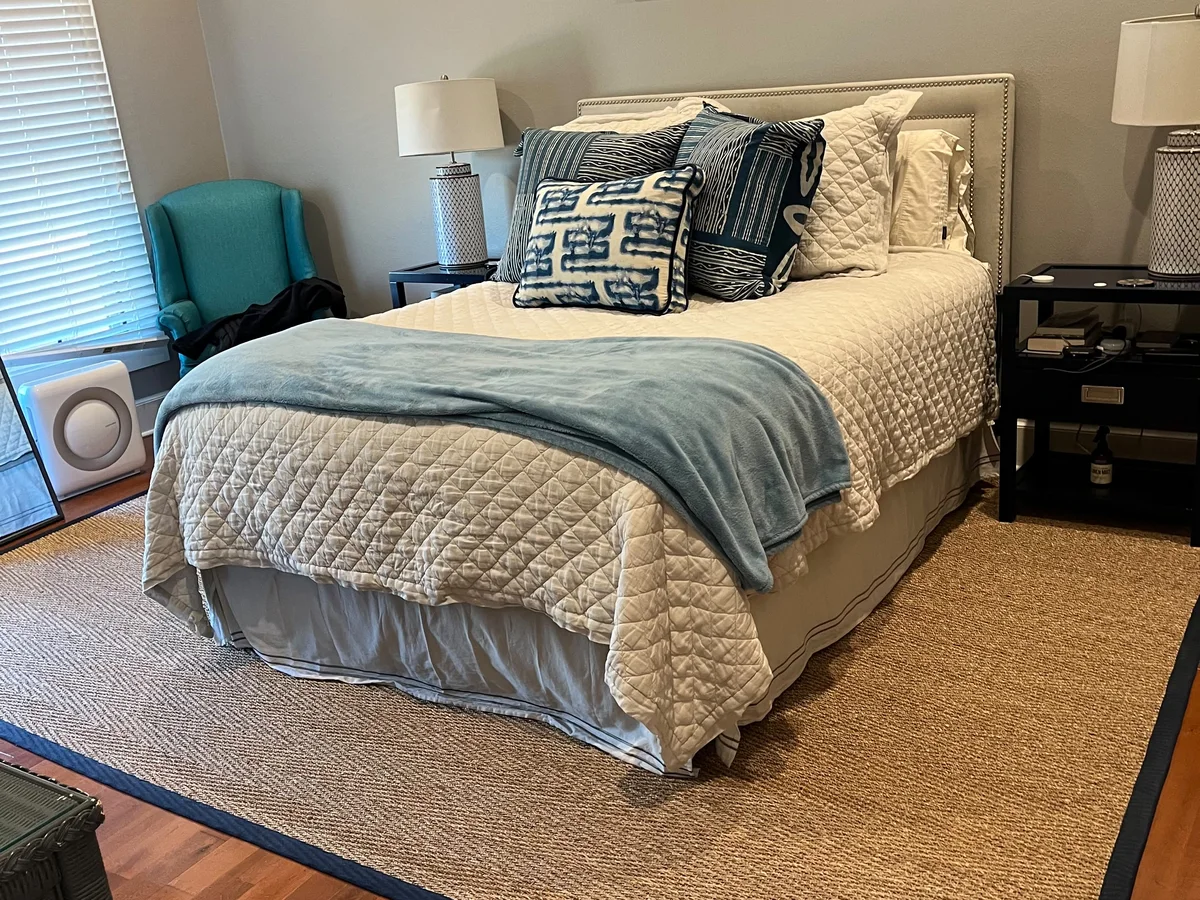Clean, made bed in a tidy bedroom we cleaned